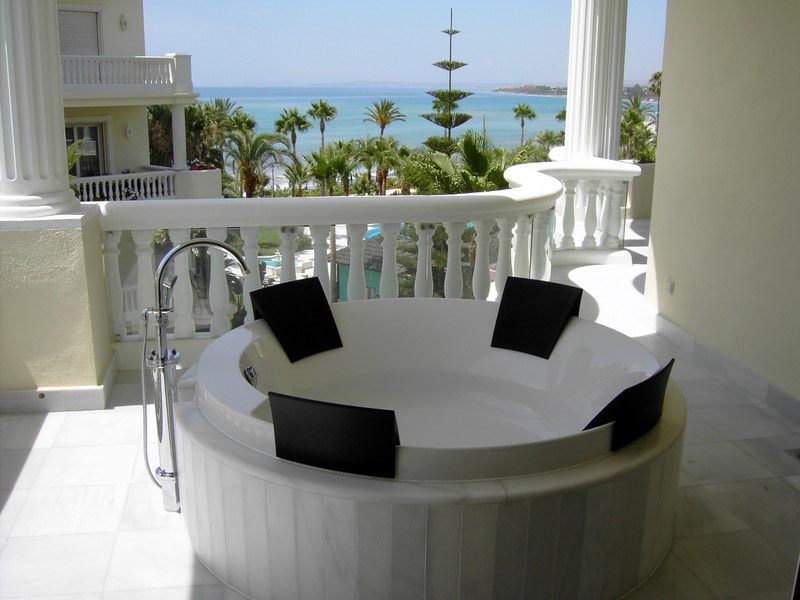 Terraza con bañera circular y balaustrada con vistas al mar en la vivienda de Marbella