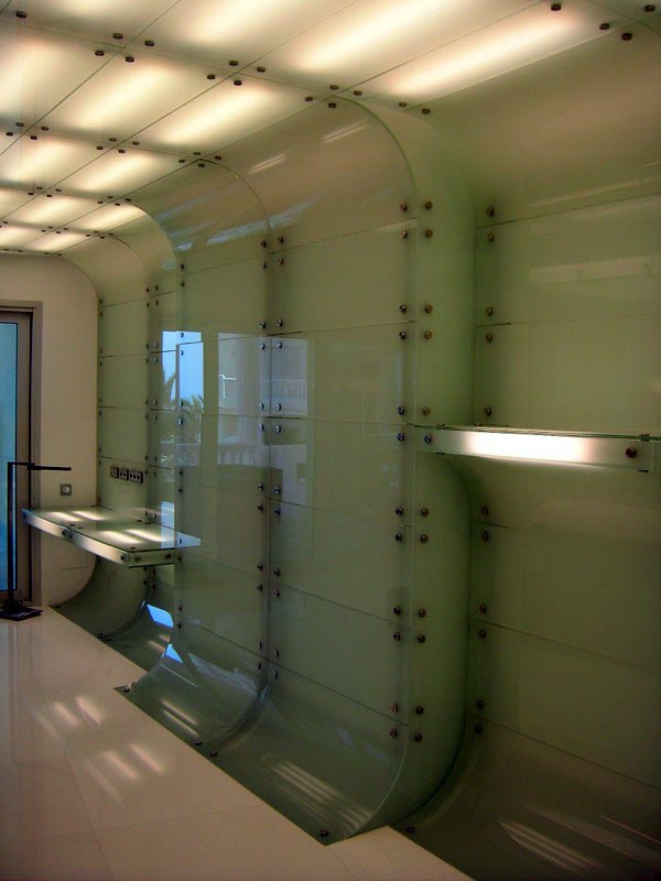 Revestimiento curvo de vidrio y falso techo retroiluminado en la vivienda de Marbella
