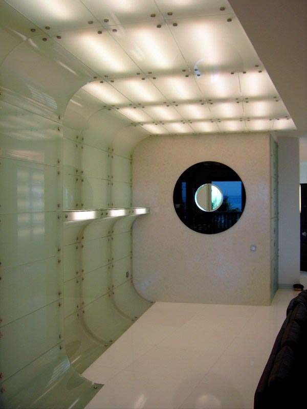 Paneles de vidrio con ventana circular y techo retroiluminado en la vivienda de Marbella