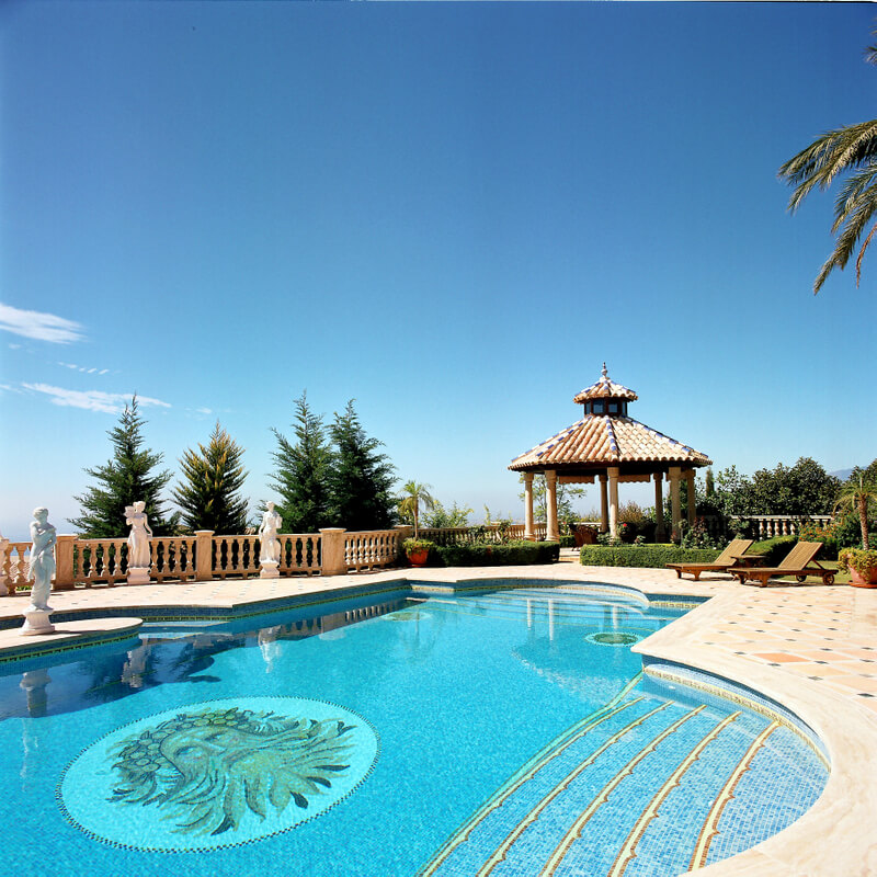 Piscina con mosaico y cenador al fondo en la villa de lujo de Marbella