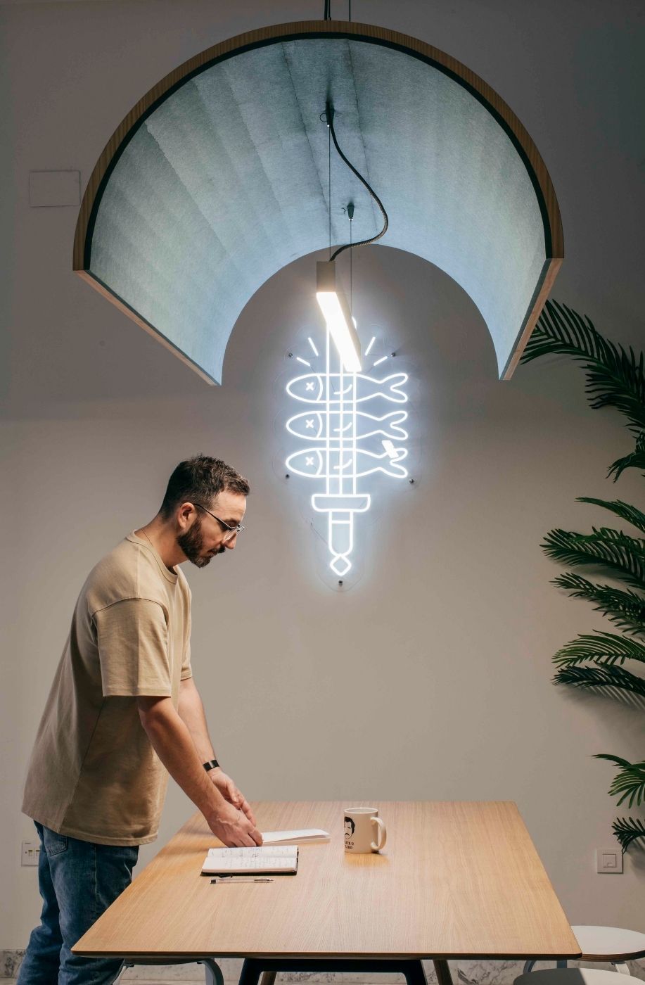 Persona trabajando junto a la mesa bajo un neón decorativo en las oficinas de Uptodown