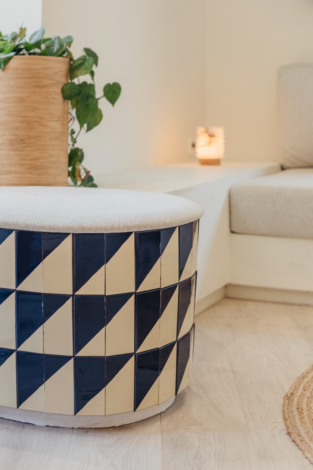 Banco circular con azulejos geométricos azules y blancos y asiento tapizado en la academia de idiomas