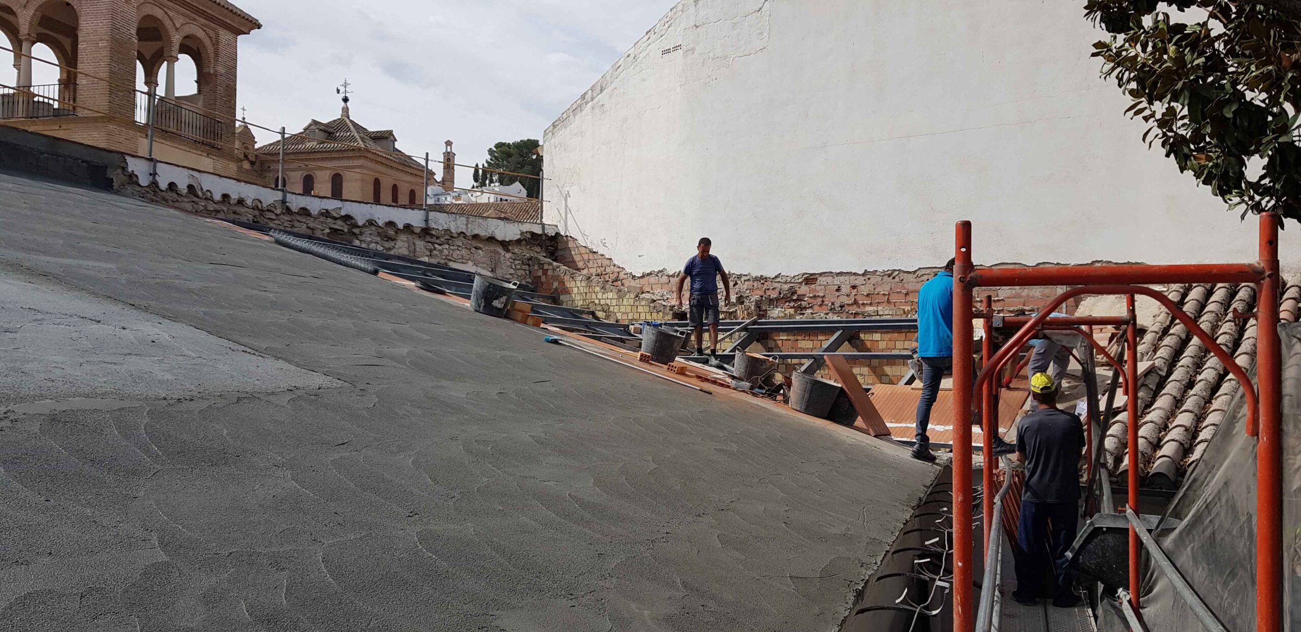 Cubierta inclinada con capa de impermeabilización y andamio en el colegio histórico