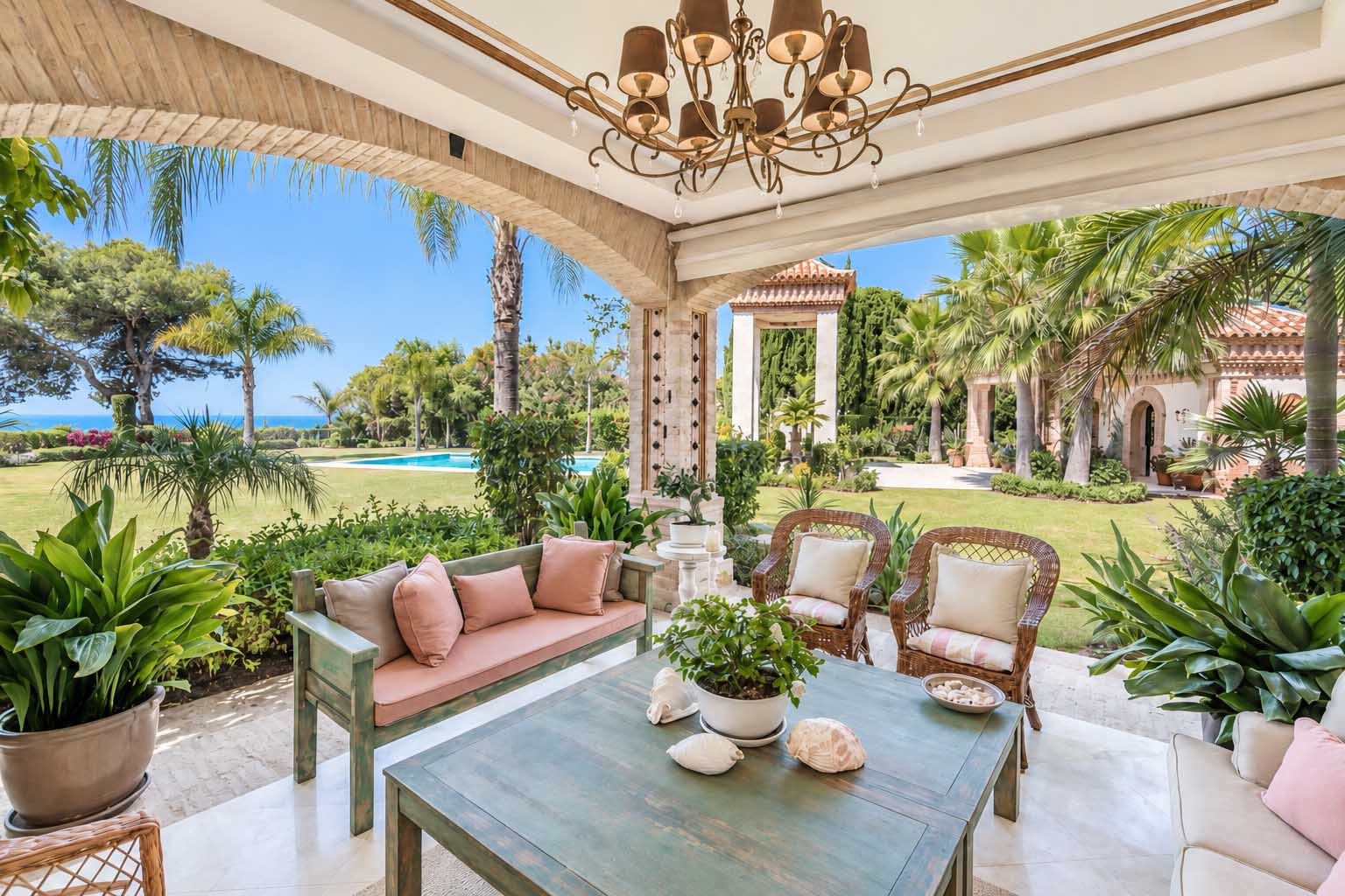 Porche con zona de estar y vistas al jardín y al mar en la Villa Alhambra