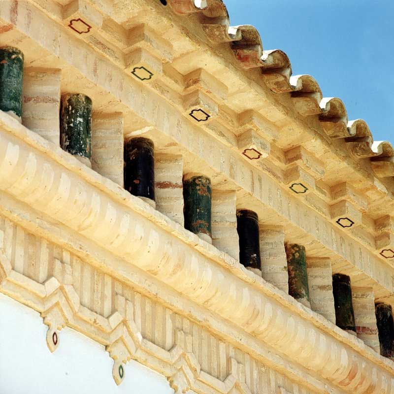 Detalle de cornisa ornamental con canecillos bajo la cubierta de teja