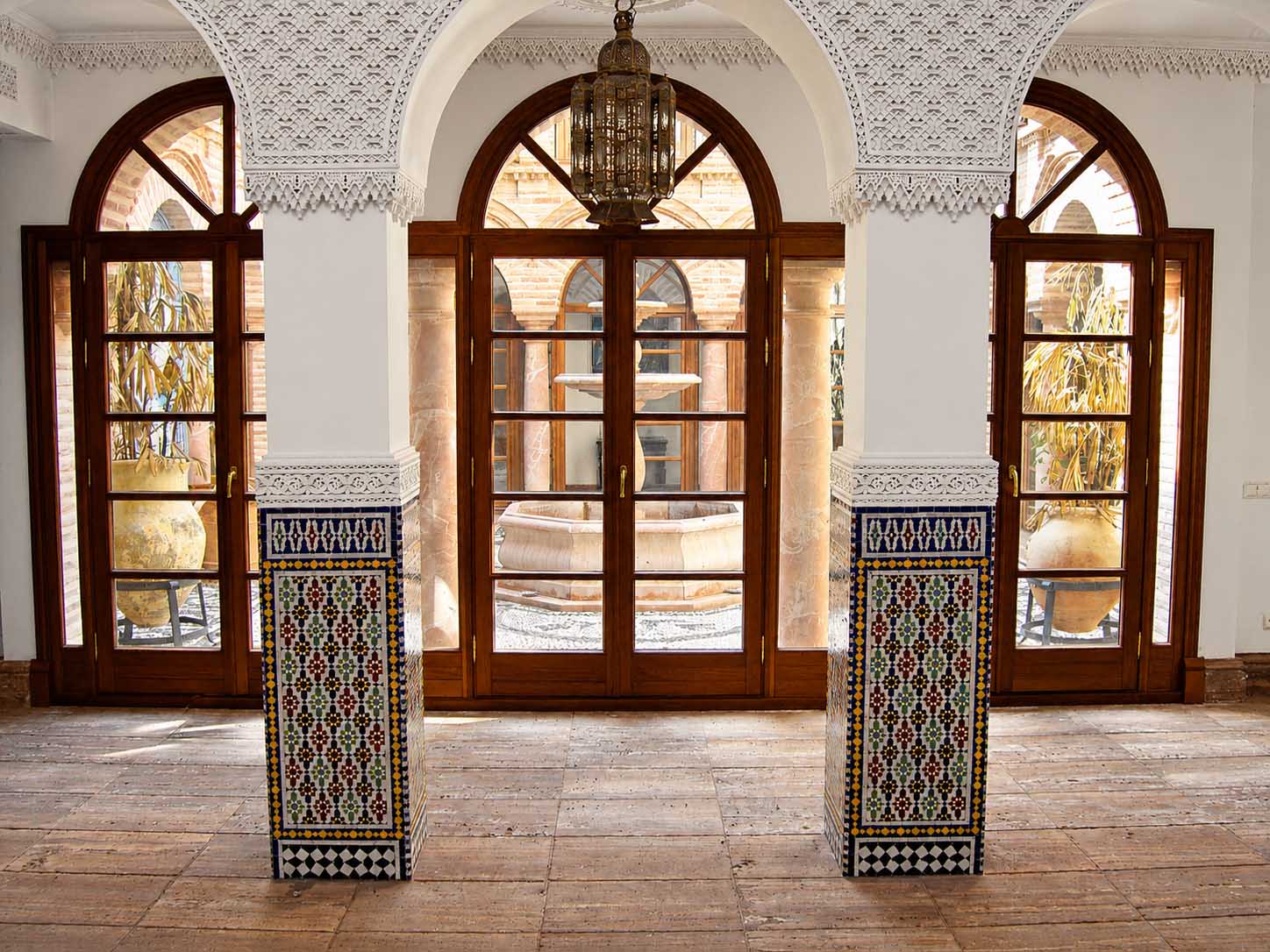 Arcos y puertas acristaladas con columnas de azulejos en el interior de la villa