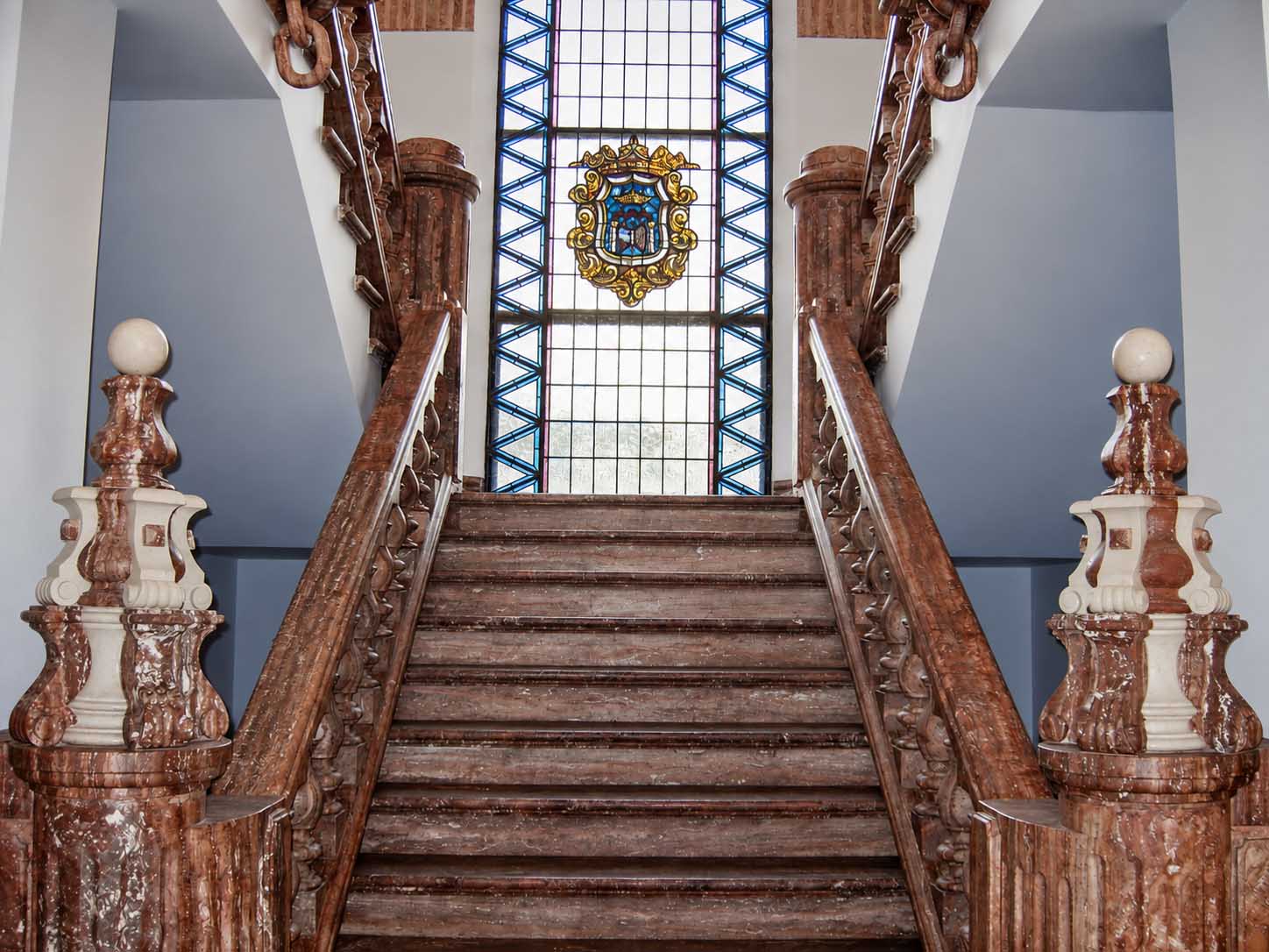 Escalera de madera con vidriera y barandilla tallada
