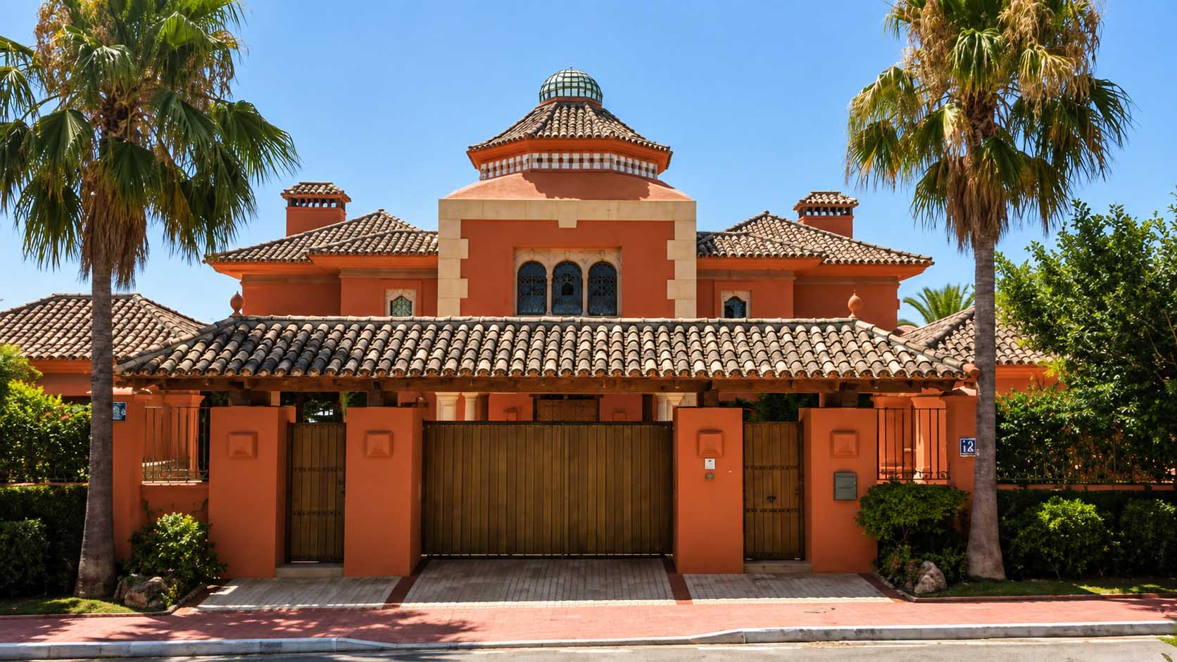 Villa de inspiración mediterránea con cubiertas de teja y palmeras en la Costa del Sol