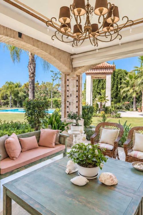 Porche con zona de estar y vistas al jardín y al mar en la Villa Alhambra